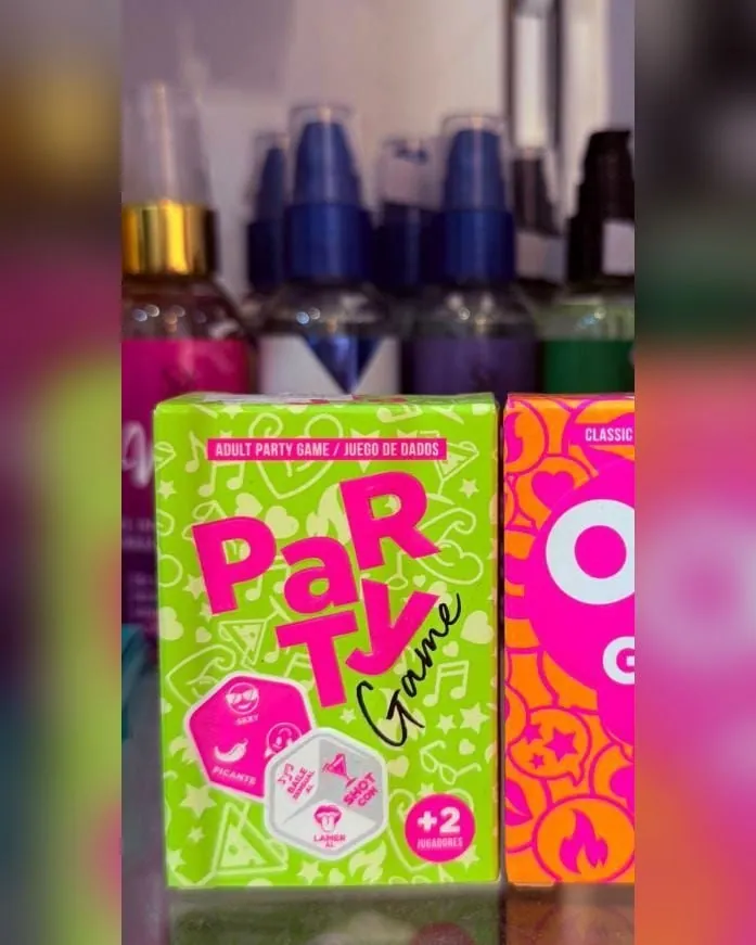 La caja verde flúor del juego de dados Party Game, con los dados dibujados en la tapa, al lado de otra caja naranja.
