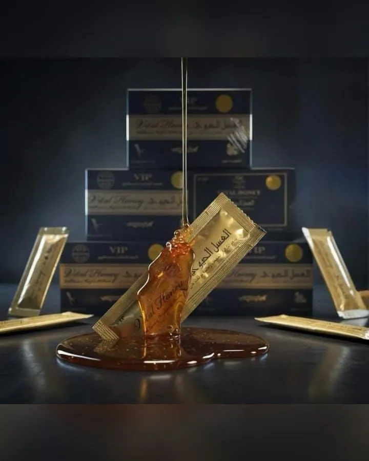 Un sobre dorado de miel Vital Honey abierto y chorreando, delante de las cajas azules en las que vienen.