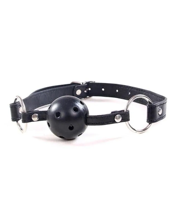 Mordaza de cuero negro con pelota perforada al centro, dos argollas metálicas a los costados y correa con hebilla regulable, sobre fondo blanco.